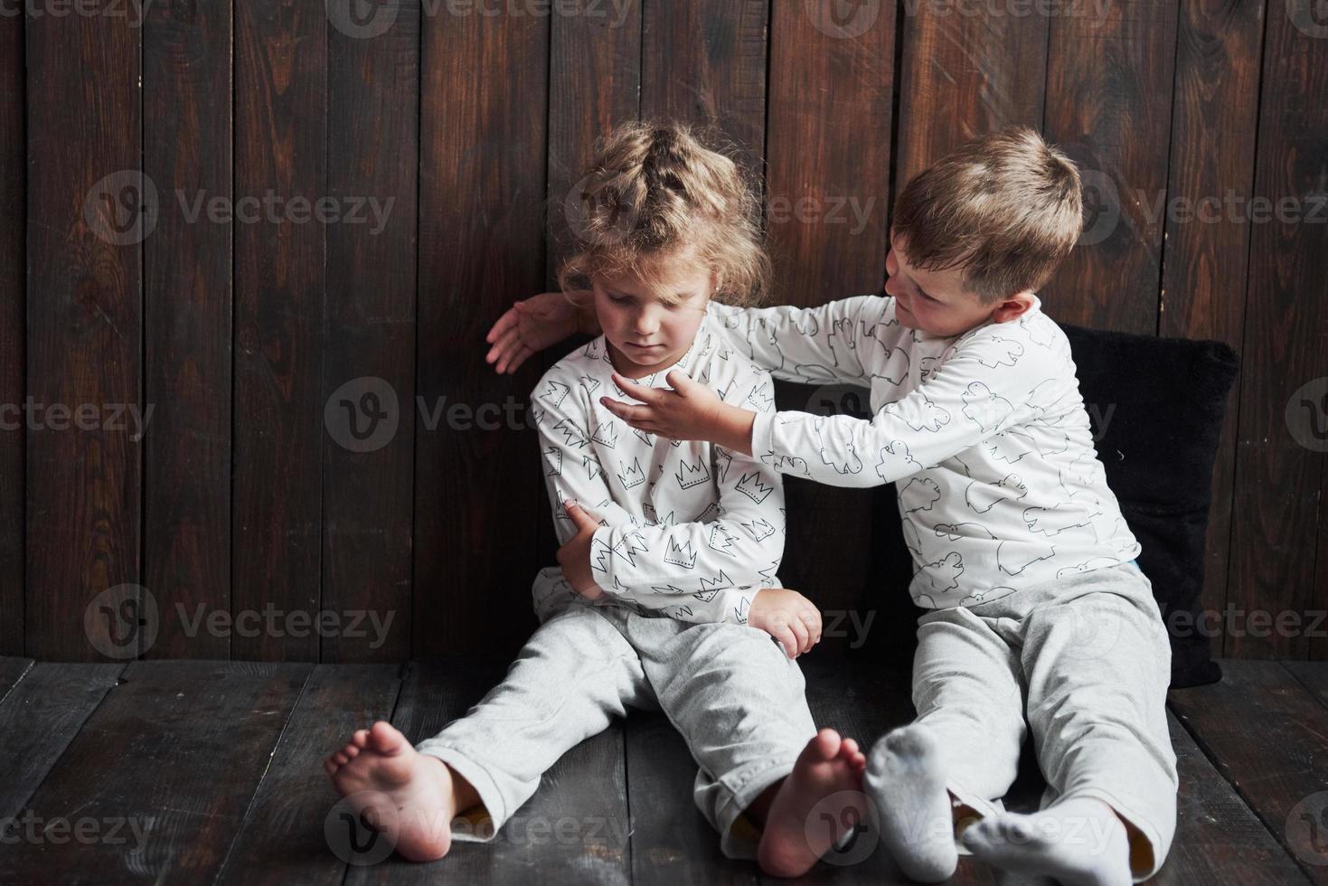 due bambini, fratello e sorella in pigiama giocano insieme foto