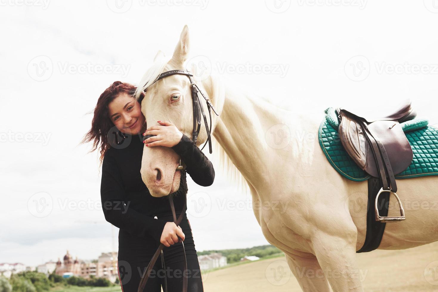 una ragazza felice comunica con il suo cavallo preferito. la ragazza ama gli animali e l'equitazione foto