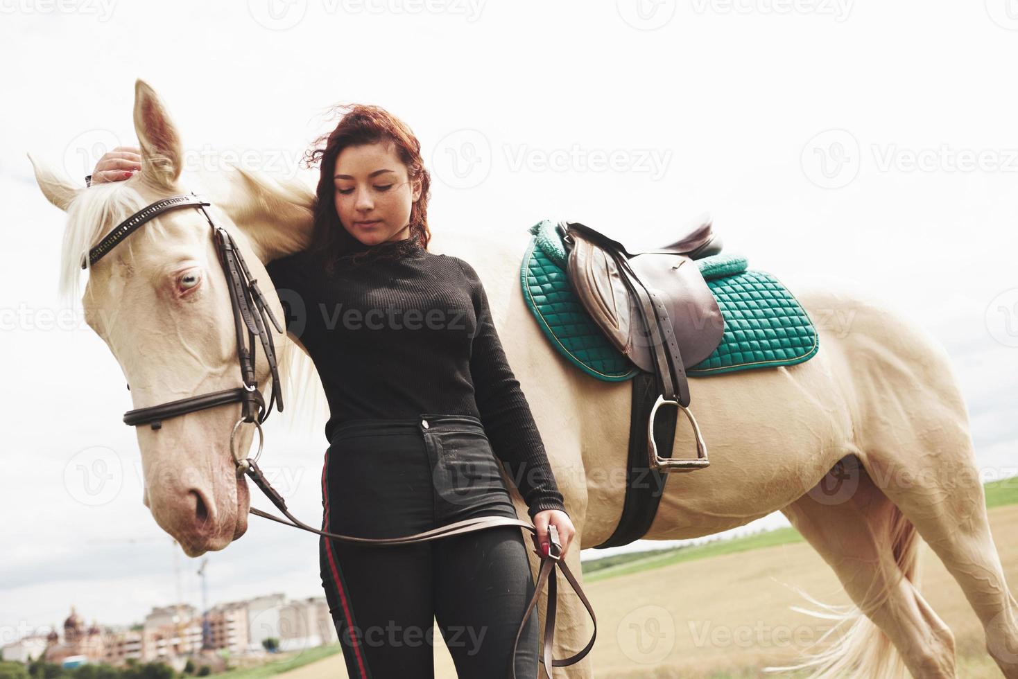 una ragazza felice comunica con il suo cavallo preferito. la ragazza ama gli animali e l'equitazione foto