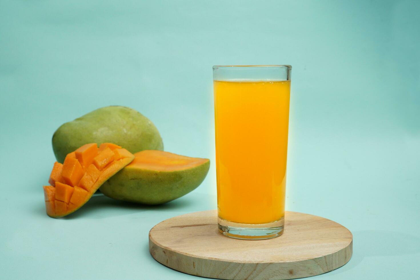 Mango bevanda su il giro vassoio con Mango frutta su blu sfondo foto