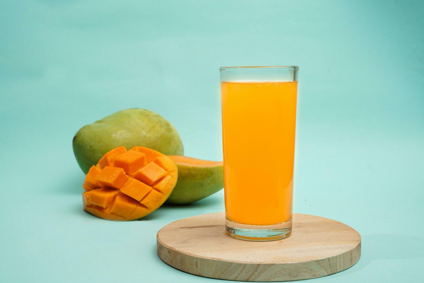 Mango bevanda su il giro vassoio con Mango frutta su blu sfondo foto