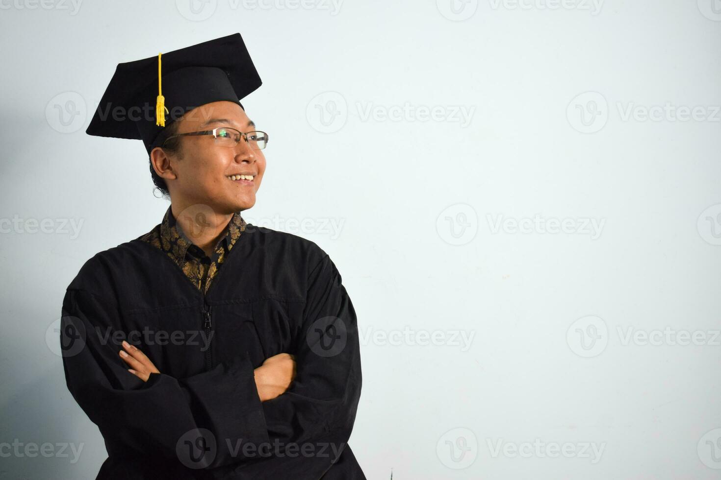 espressive di adulto Indonesia maschio indossare la laurea veste, cappello e occhiali isolato su bianca sfondo, espressioni di ritratto la laurea foto