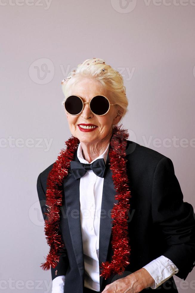 bella donna anziana in smoking e occhiali da sole alla festa. divertimento, festa, stile, concetto di celebrazione foto