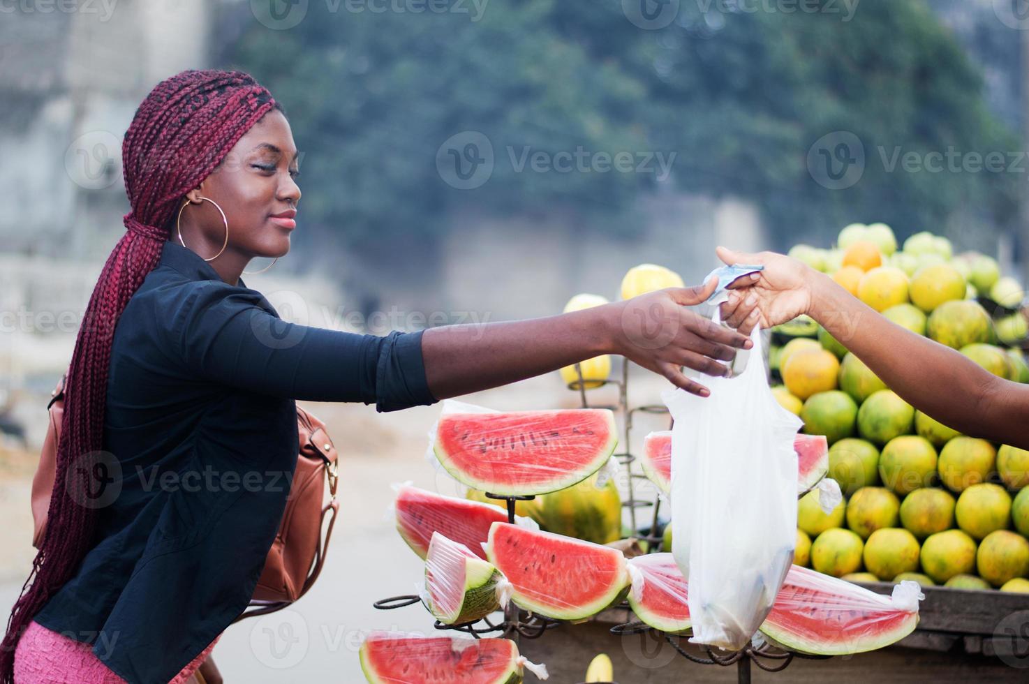 giovane donna che compra frutta. foto