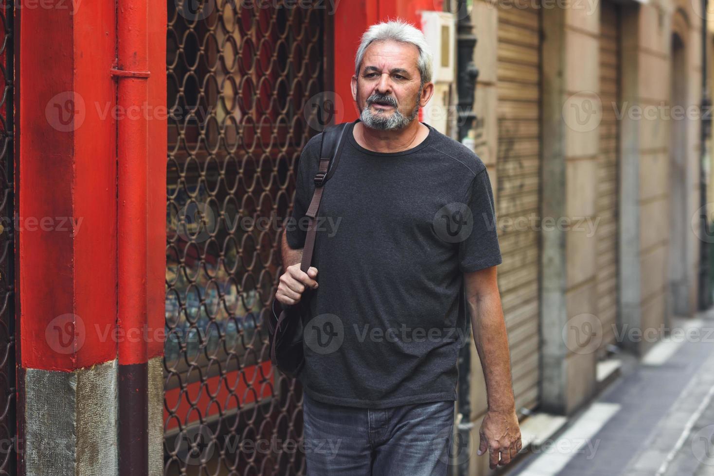 turista maturo uomo con zaino da viaggio in background urbano. foto