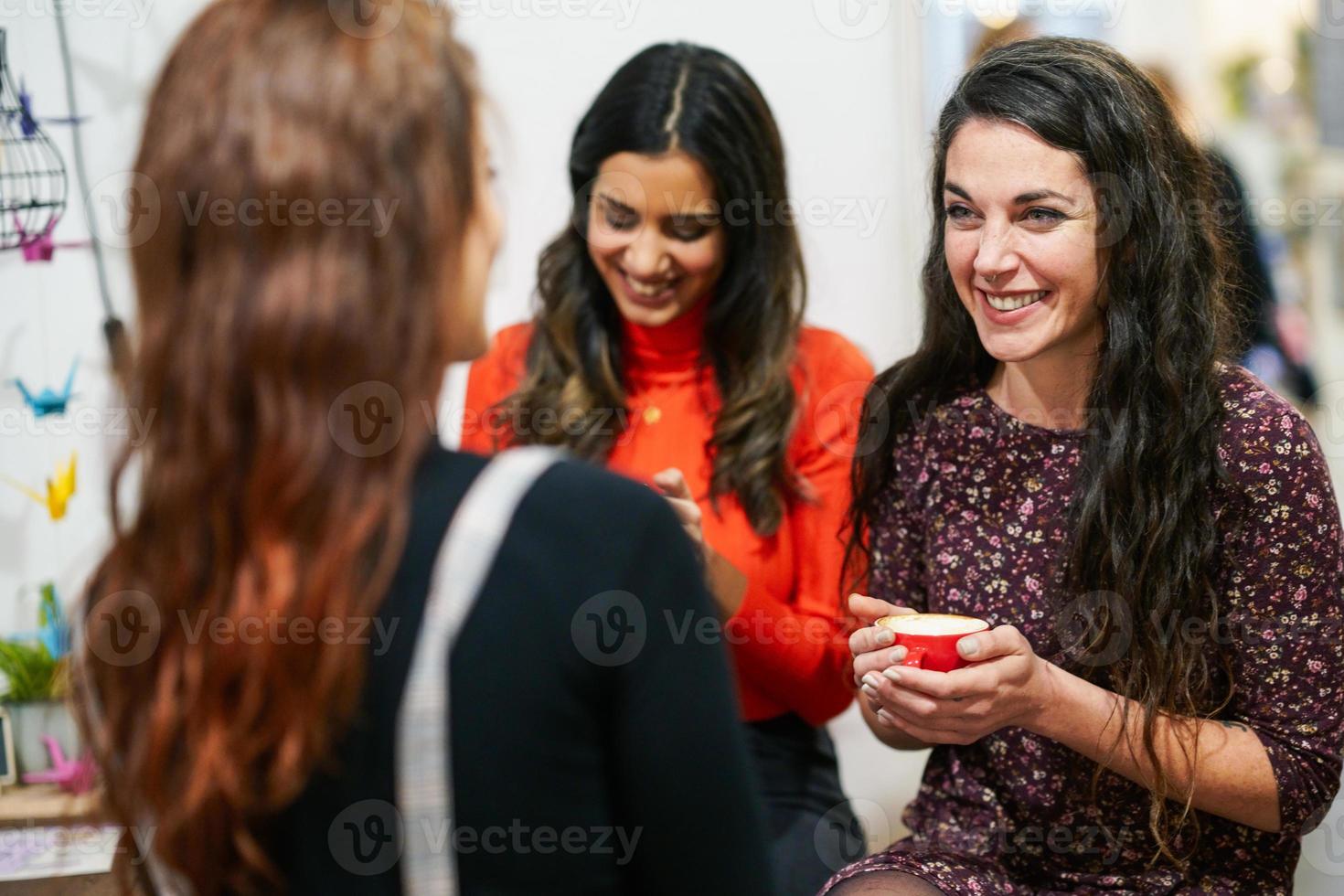 gruppo di tre amici felici che bevono caffè in un bar caffetteria. foto