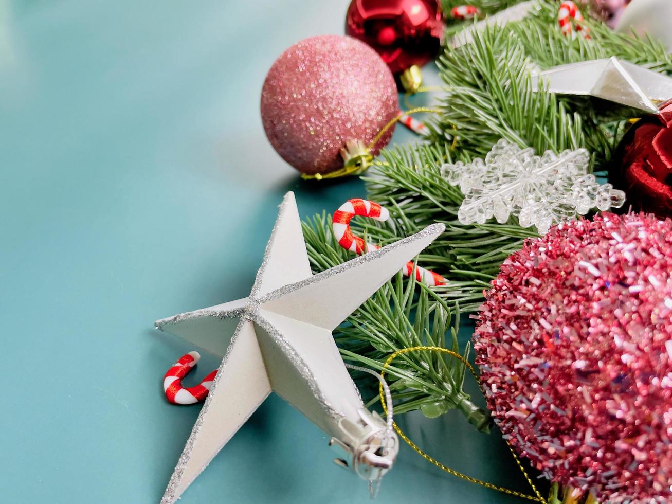 decorazioni natalizie, foglie di pino, palline rosse, fiocchi di neve, bacche rosse su sfondo blu foto