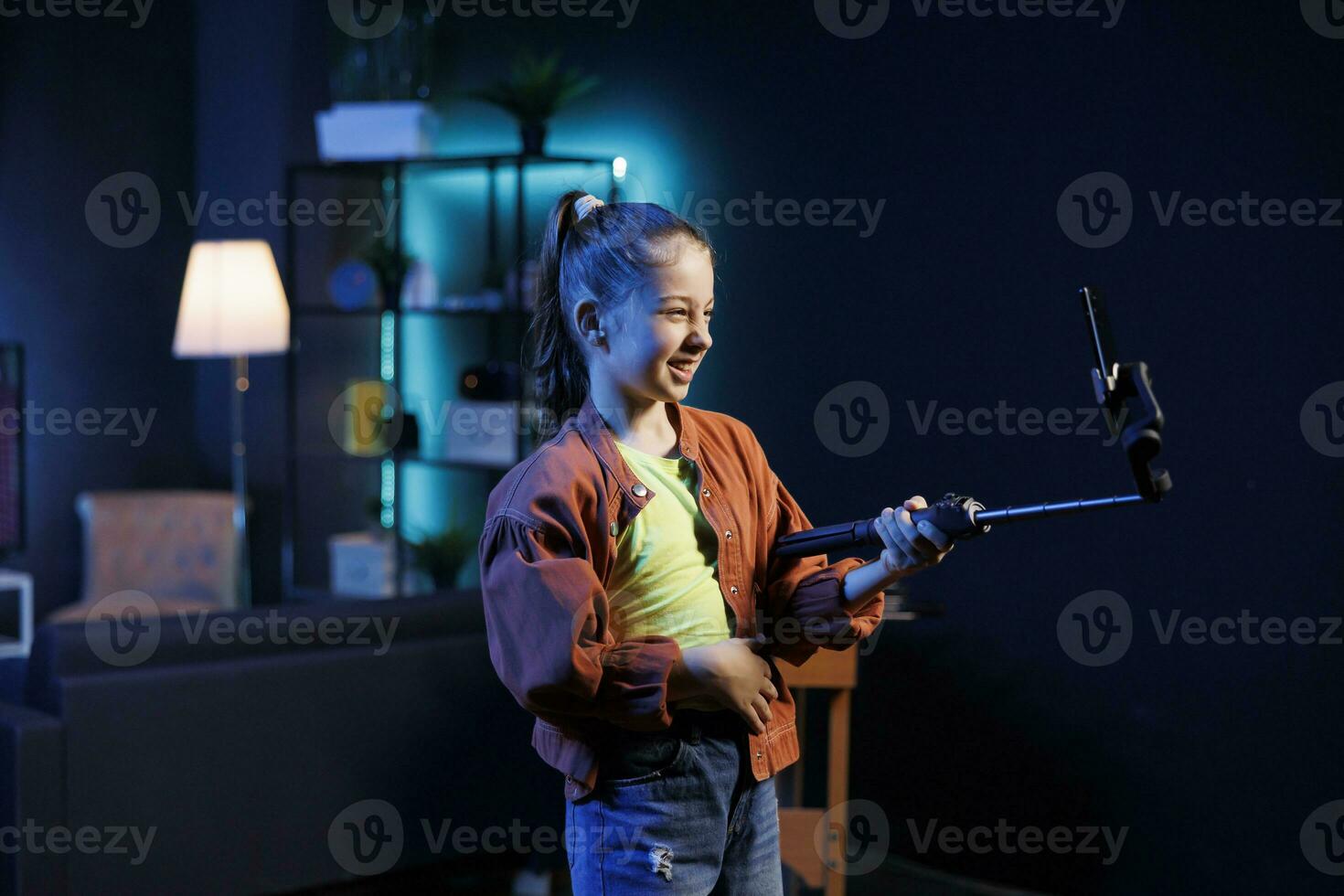 giovane bambino assunzione parte nel virale danza tendenza dopo vedendo preferito celebrità fare esso, le riprese video con smartphone su autoscatto bastone. talentuoso giovanotto fa di moda danza sfida foto