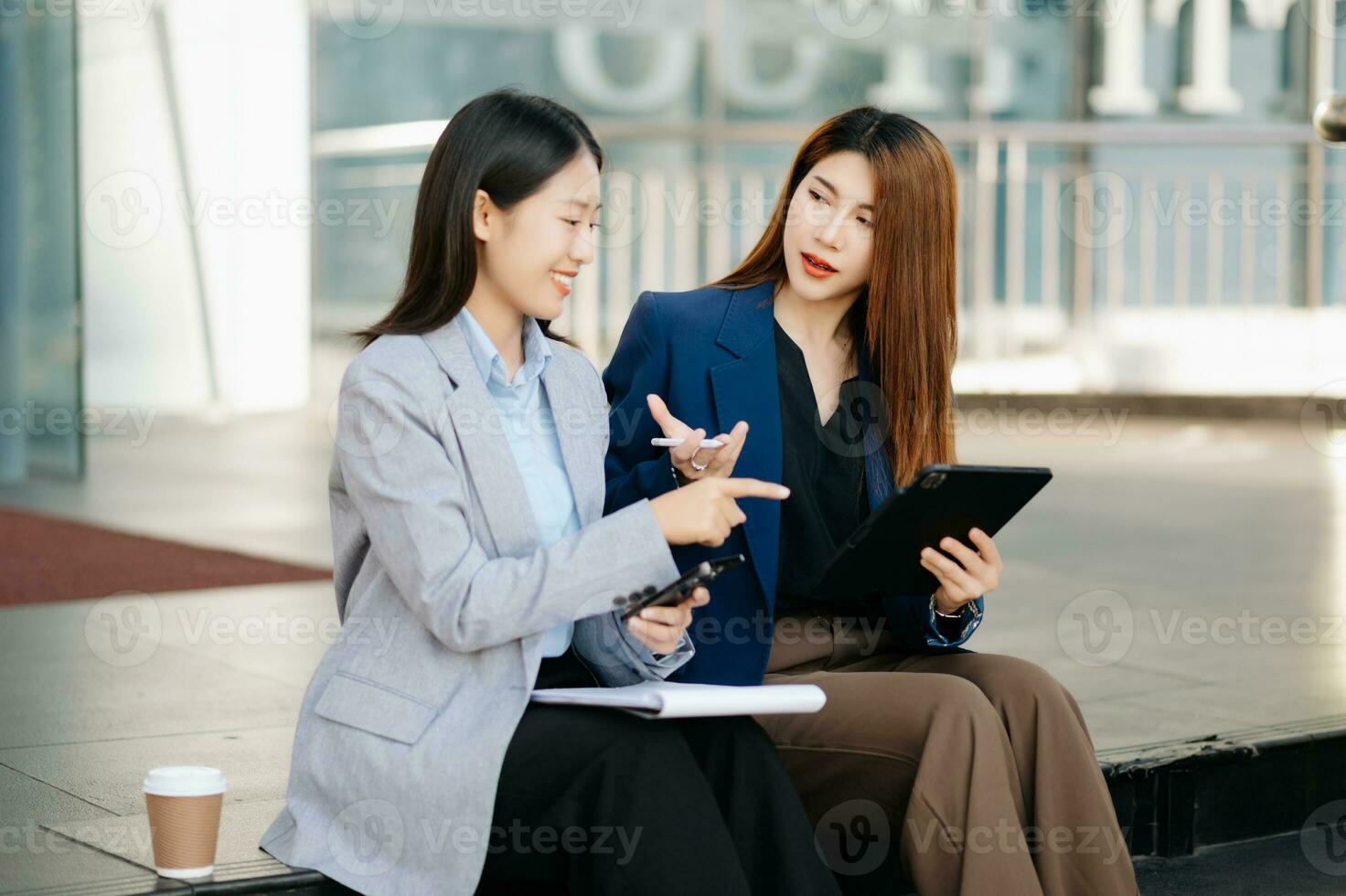 donna d'affari e donna andando nel città centro nel inteligente casuale attività commerciale stile, parlando, Lavorando insieme, elegante libero professionista le persone, Tenere tavoletta foto