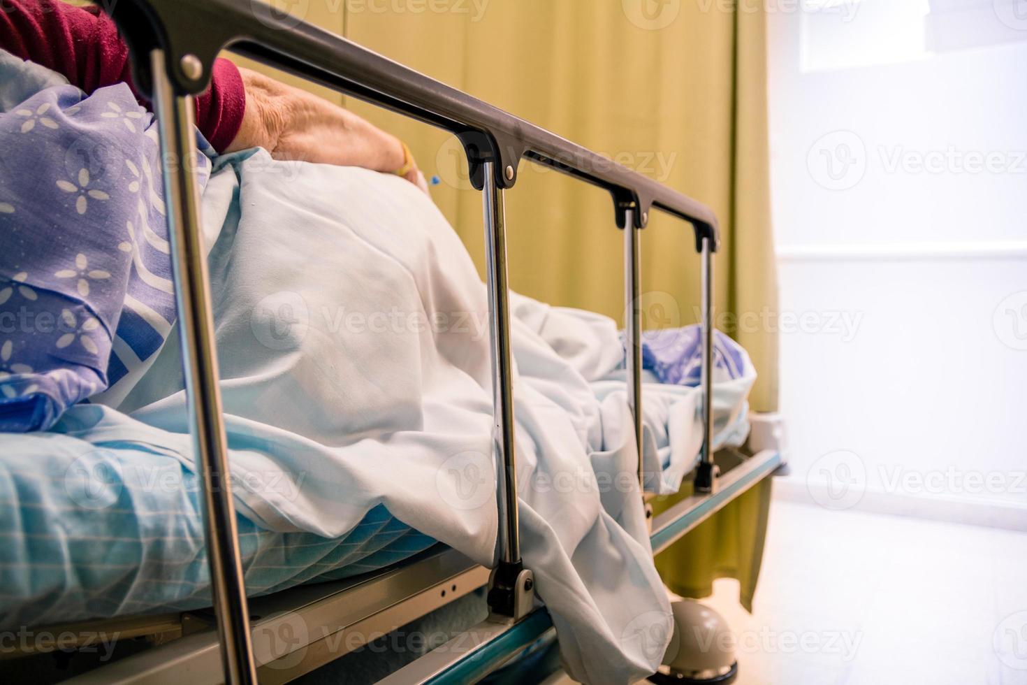 paziente donna sdraiata su un letto in una stanza d'ospedale foto