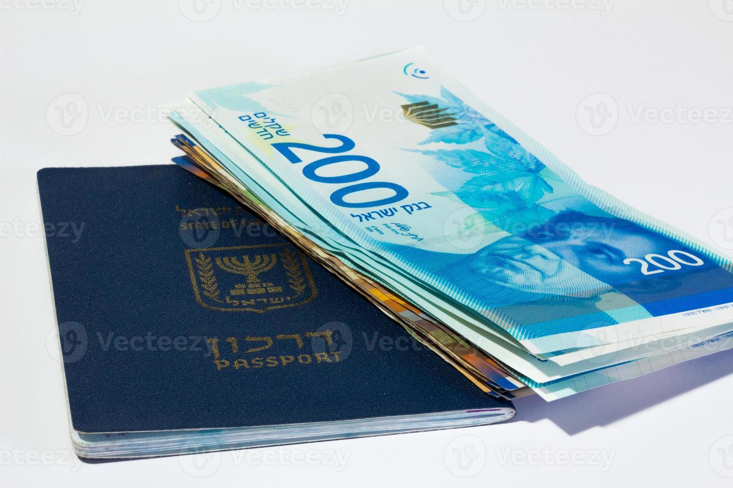 pila di banconote israeliane da 200 sicli e passaporto israeliano foto