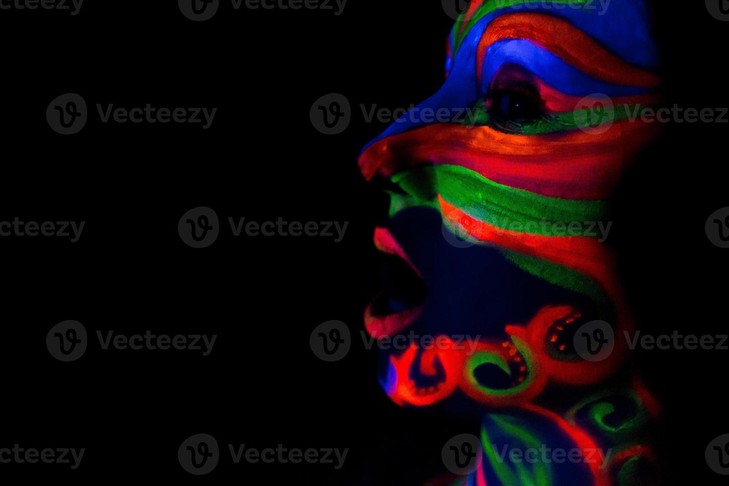 donna con arte del trucco di polvere fluorescente uv incandescente foto