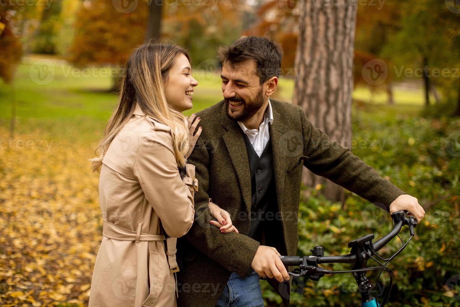giovane coppia nel parco autunnale con bicicletta elettrica foto