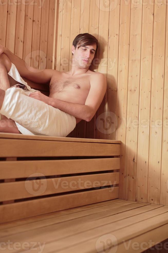 giovane che si rilassa nella sauna foto