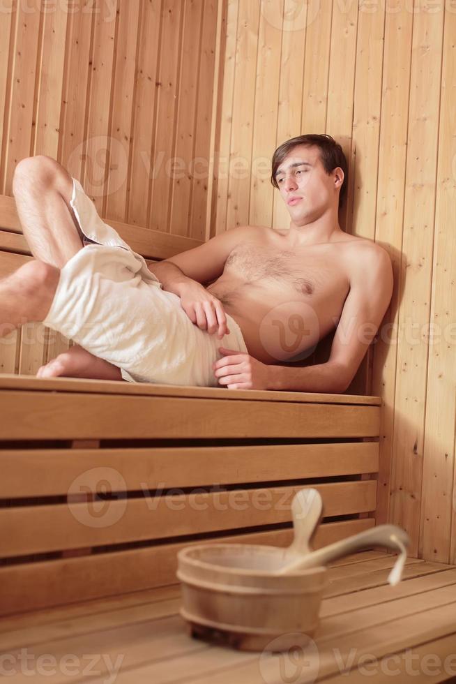 giovane che si rilassa nella sauna foto