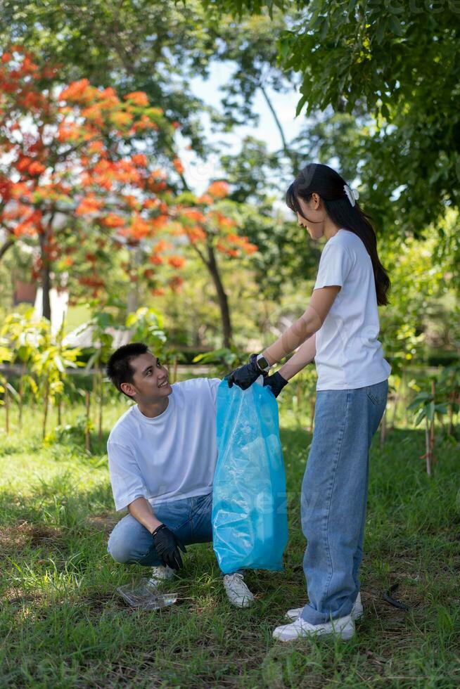 contento giovane asiatico studenti diverso volontari con spazzatura borse pulizia la zona nel il parco, il concetto di ambientale conservazione su mondo ambiente giorno, raccolta differenziata, beneficenza per sostenibilità. foto