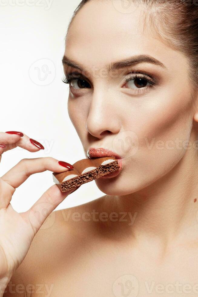 bello sorridente adolescenziale ragazza mangiare cioccolato foto