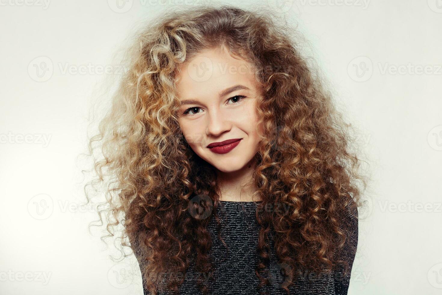 bellezza giovane donna con Riccio grande e lungo capelli. foto