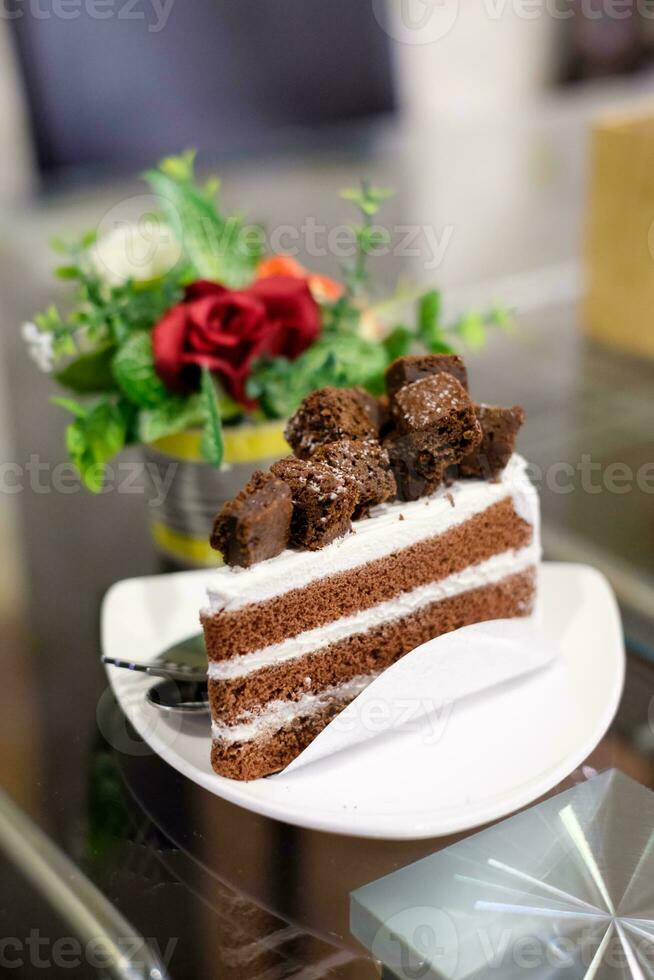 cioccolato torta e bianca crema con fiore pentola su tavolo foto