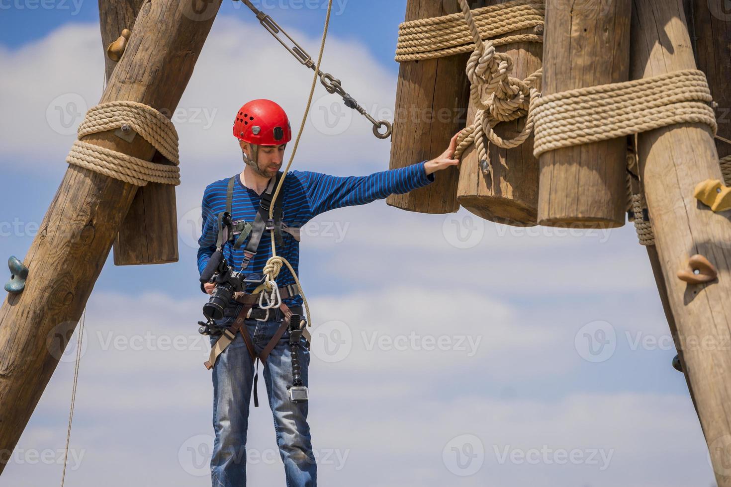 videografo professionista estremo durante le riprese sulla torre di arrampicata che lavora in condizioni estreme foto