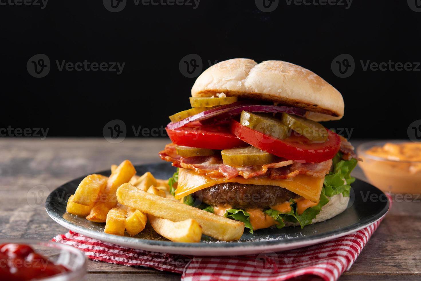 hamburger di manzo con formaggio, bacon e patatine fritte foto