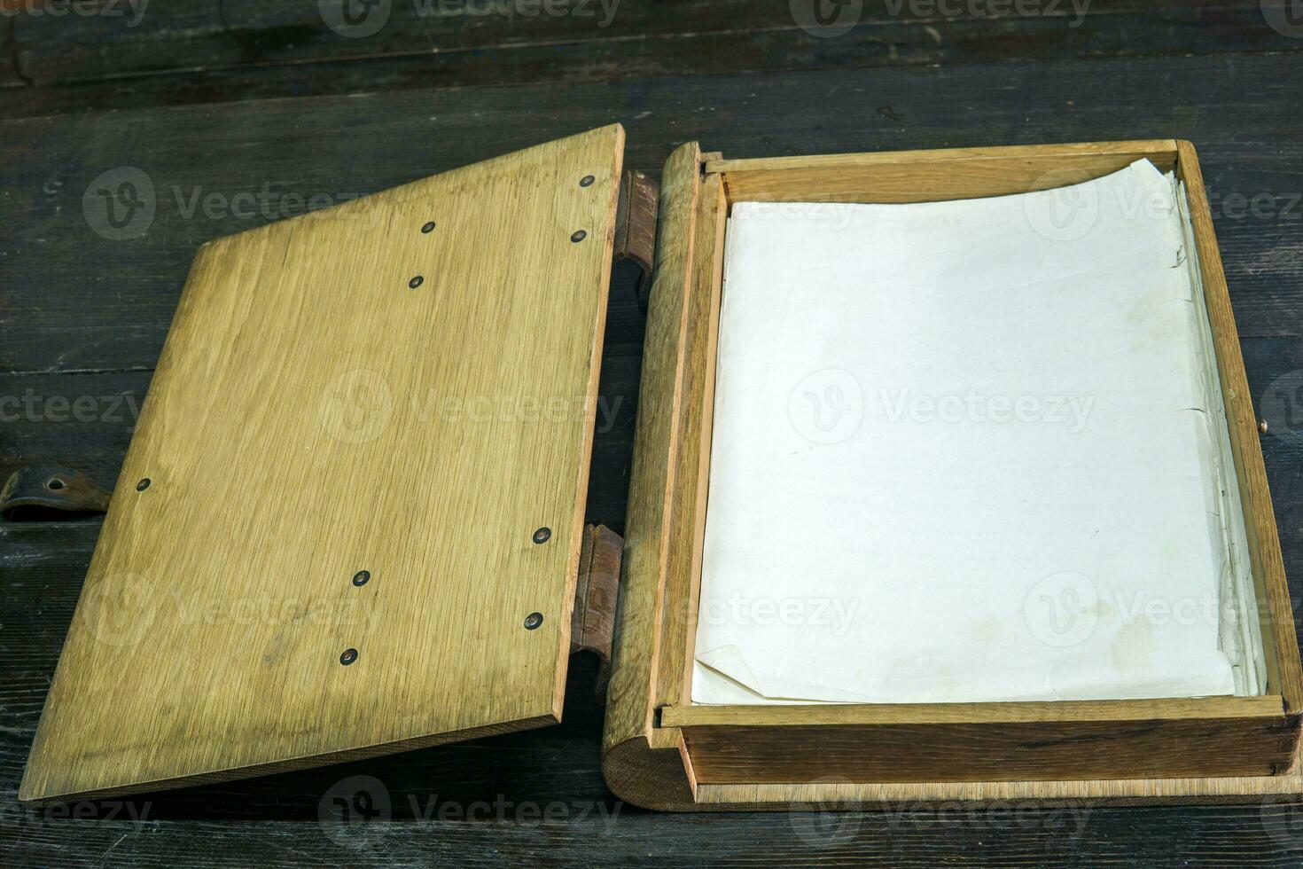 vecchio log libro nel un' di legno Astuccio con fermagli su un' nero tavolo, Aperto foto