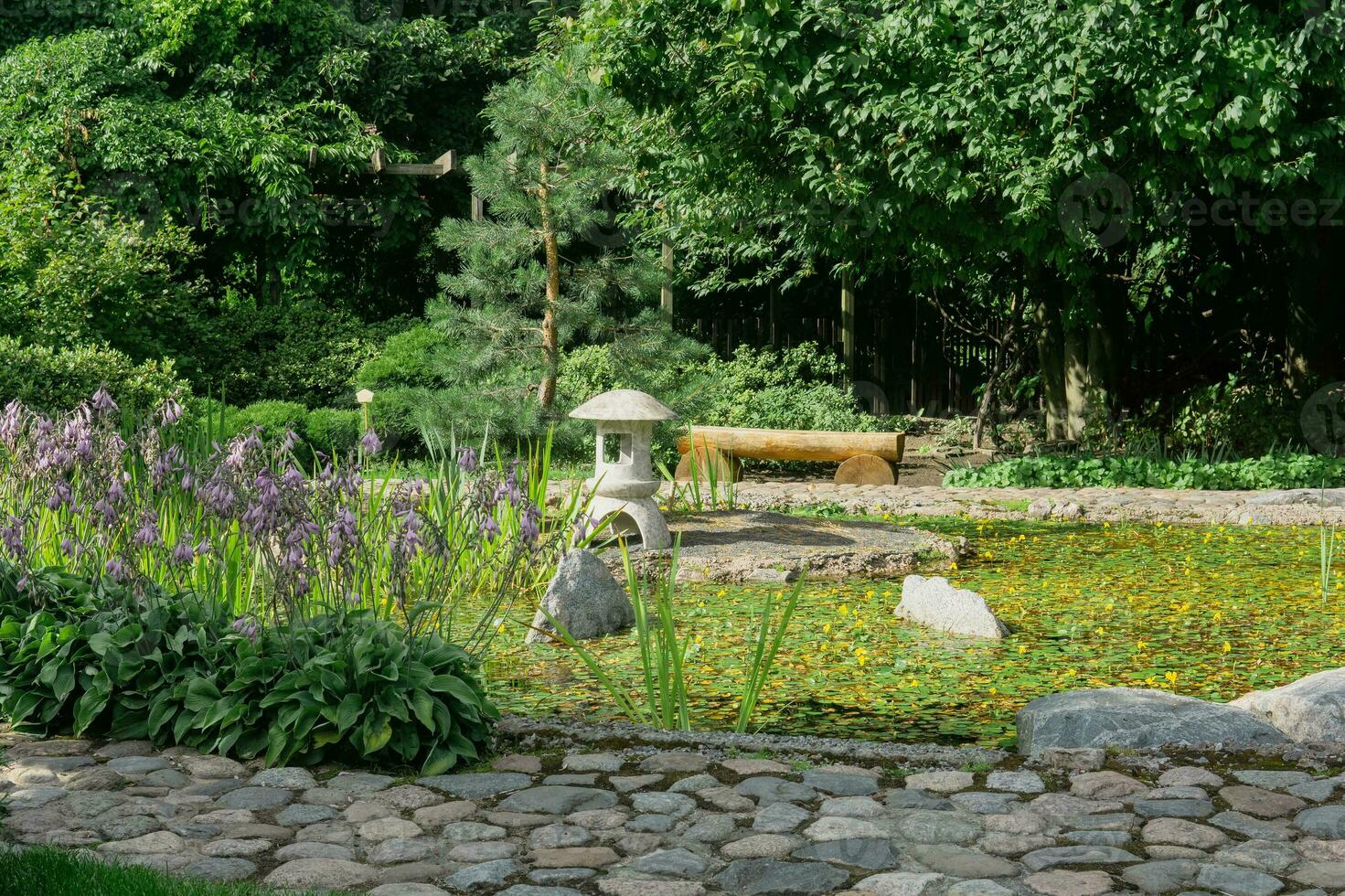 pietra lanterna su un' piccolo isola nel il mezzo di un' stagno nel un' giapponese giardino foto