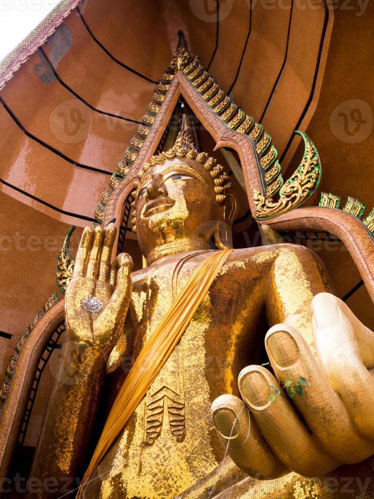 simbolo del crisantemo d'argento e foglia d'oro nel palmo della statua del buddha foto