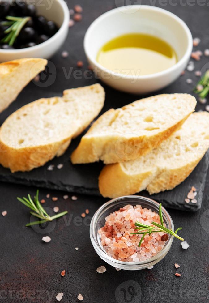 baguette fresche croccanti affettate con olive e spezie foto