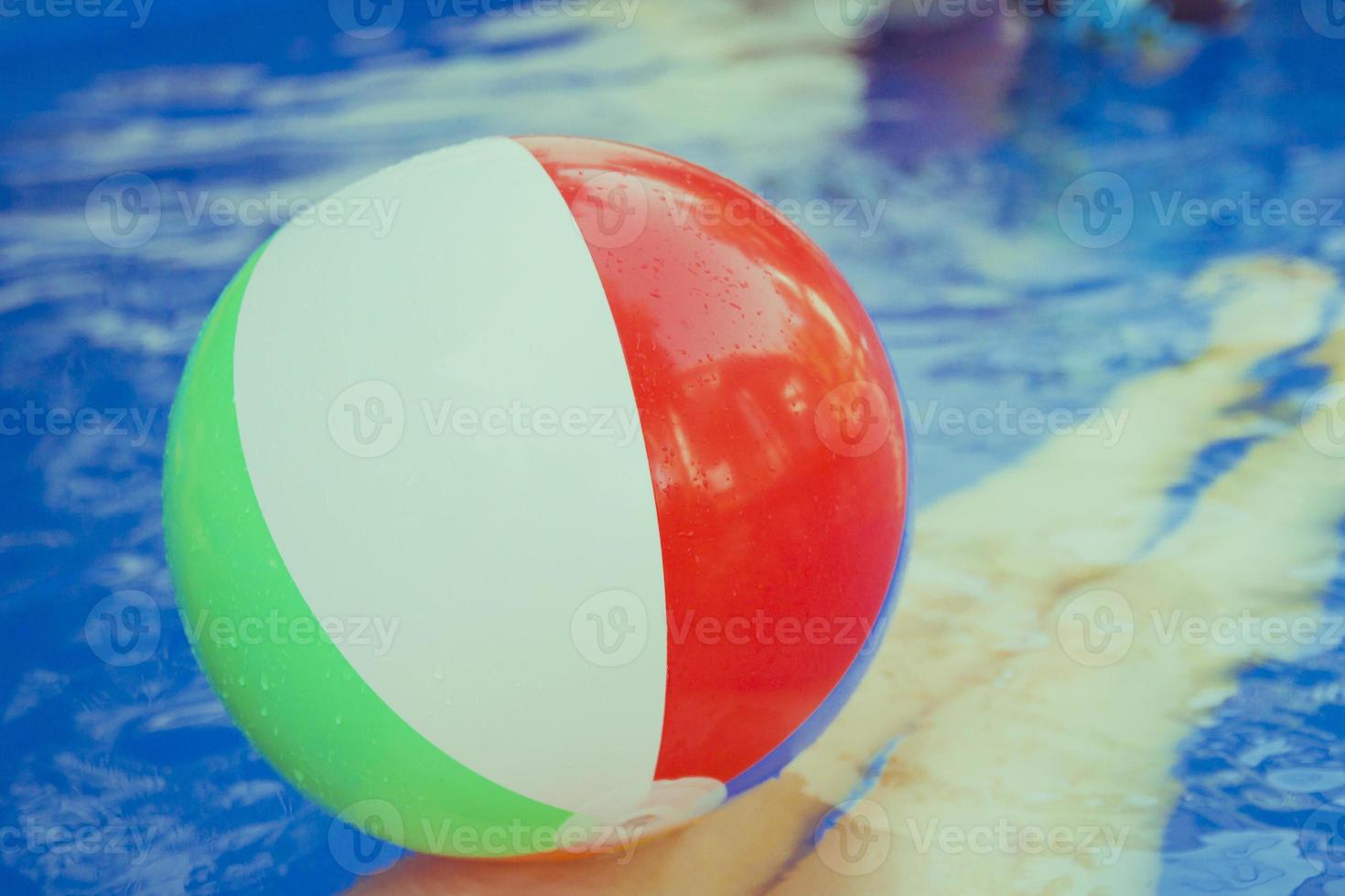 pallone da spiaggia colorato che galleggia in piscina foto