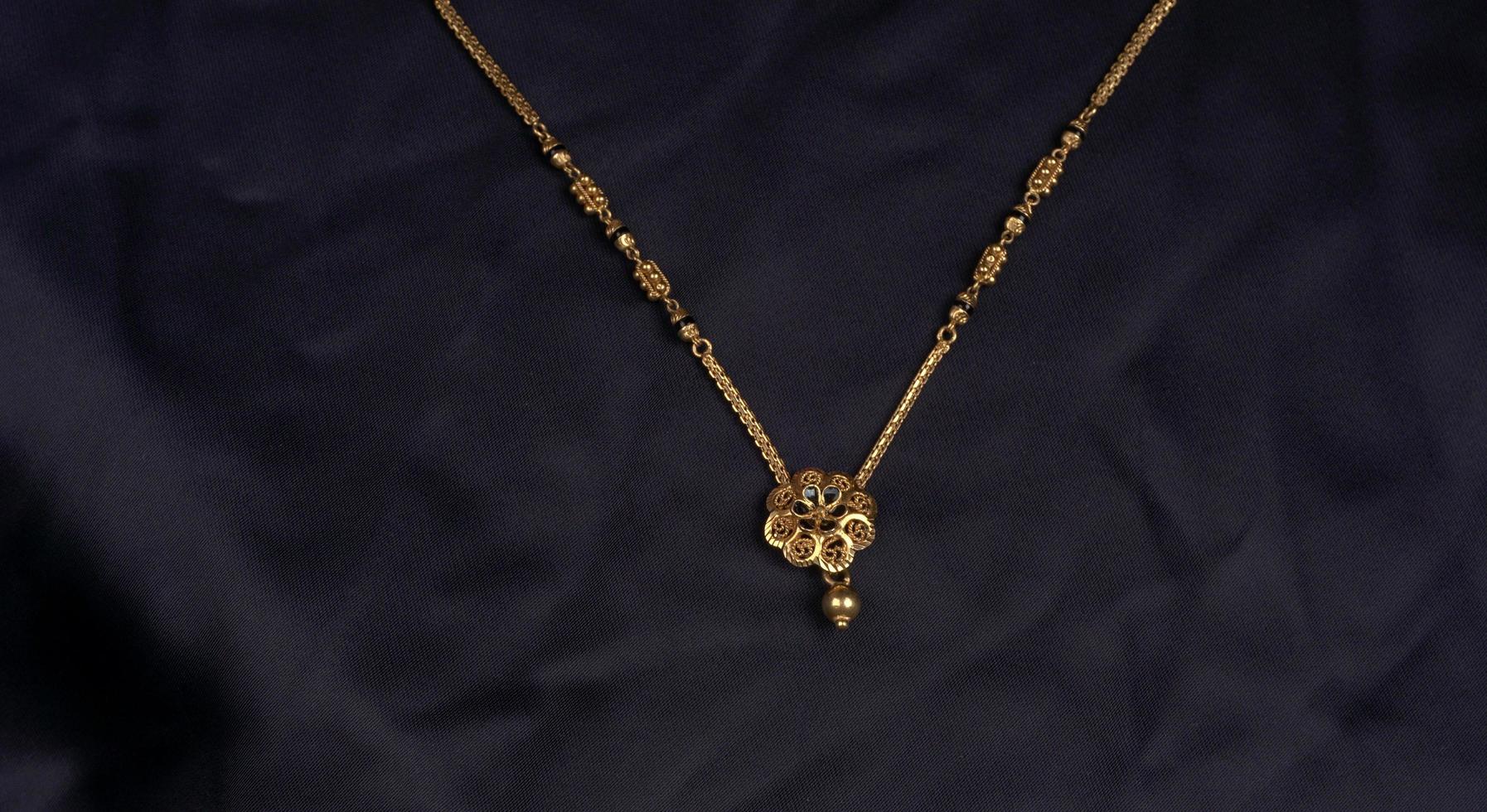 mangalsutra o collana d'oro da indossare da una donna indù sposata, disposta con un bellissimo sfondo. gioielli tradizionali indiani. foto