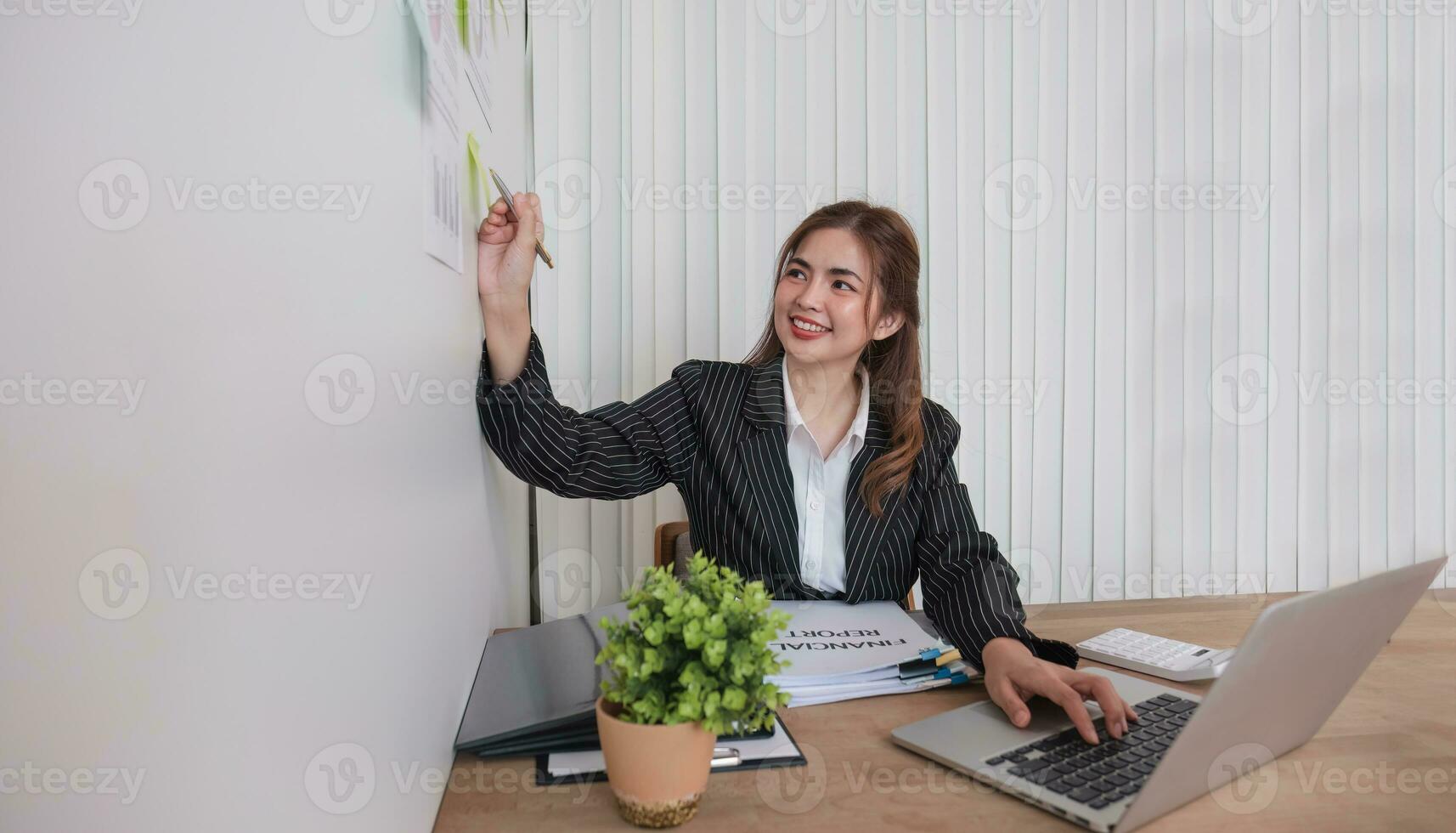 ritratto giovane donna d'affari presentazione marketing e profitto con fiducioso a ufficio, investimento e seminario per pianificazione di finanza, attività commerciale donna in piedi spiegando grafico e grafico. foto