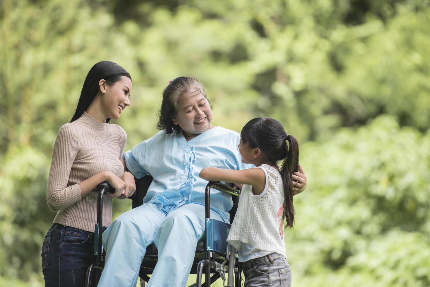 nonna felice in sedia a rotelle con sua figlia e suo nipote in un parco, vita felice tempo felice. foto