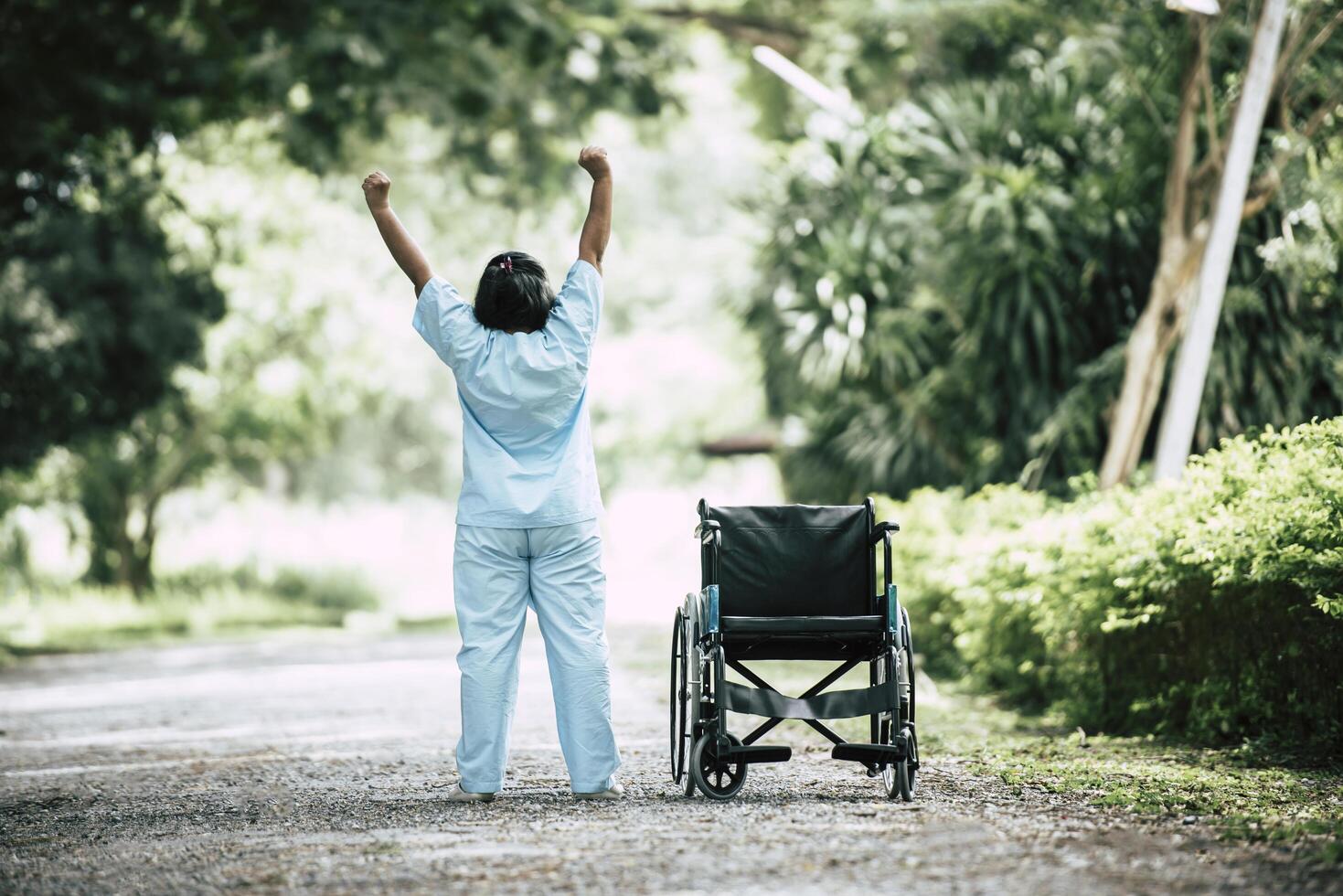 donna anziana di terapia fisica con sedia a rotelle nel parco foto