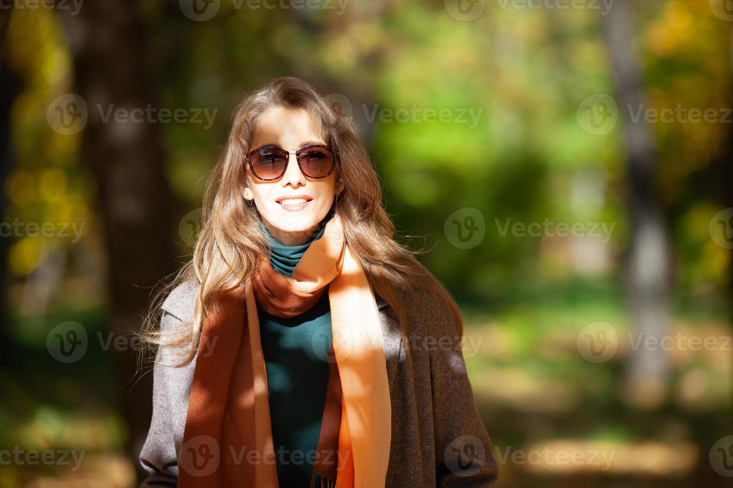 giovane donna in occhiali da sole nella foresta autunnale foto
