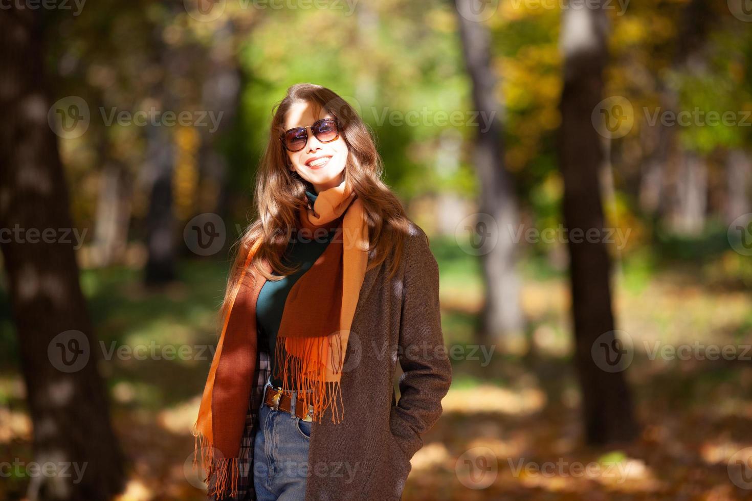 ritratto di una giovane e bella donna in occhiali da sole nella foresta autunnale foto