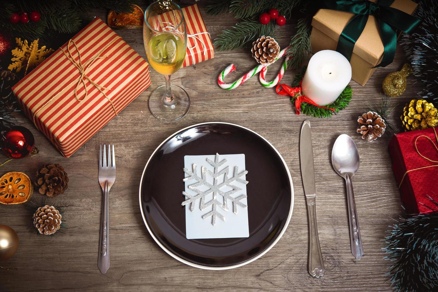 buon Natale e Felice Anno nuovo. impostazione del piatto della cena sulla vista del piano del tavolo in legno. foto