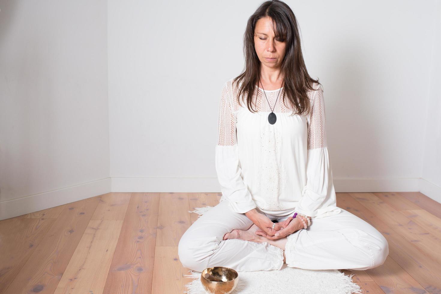 bella donna caucasica adulta durante una sessione di meditazione. seduta yoga a gambe incrociate posa. foto