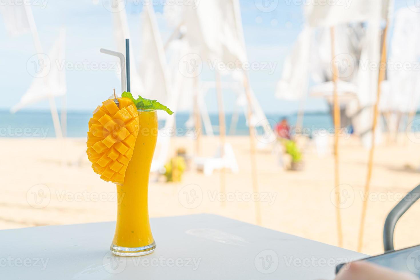 frullati di mango con sfondo di spiaggia di mare foto