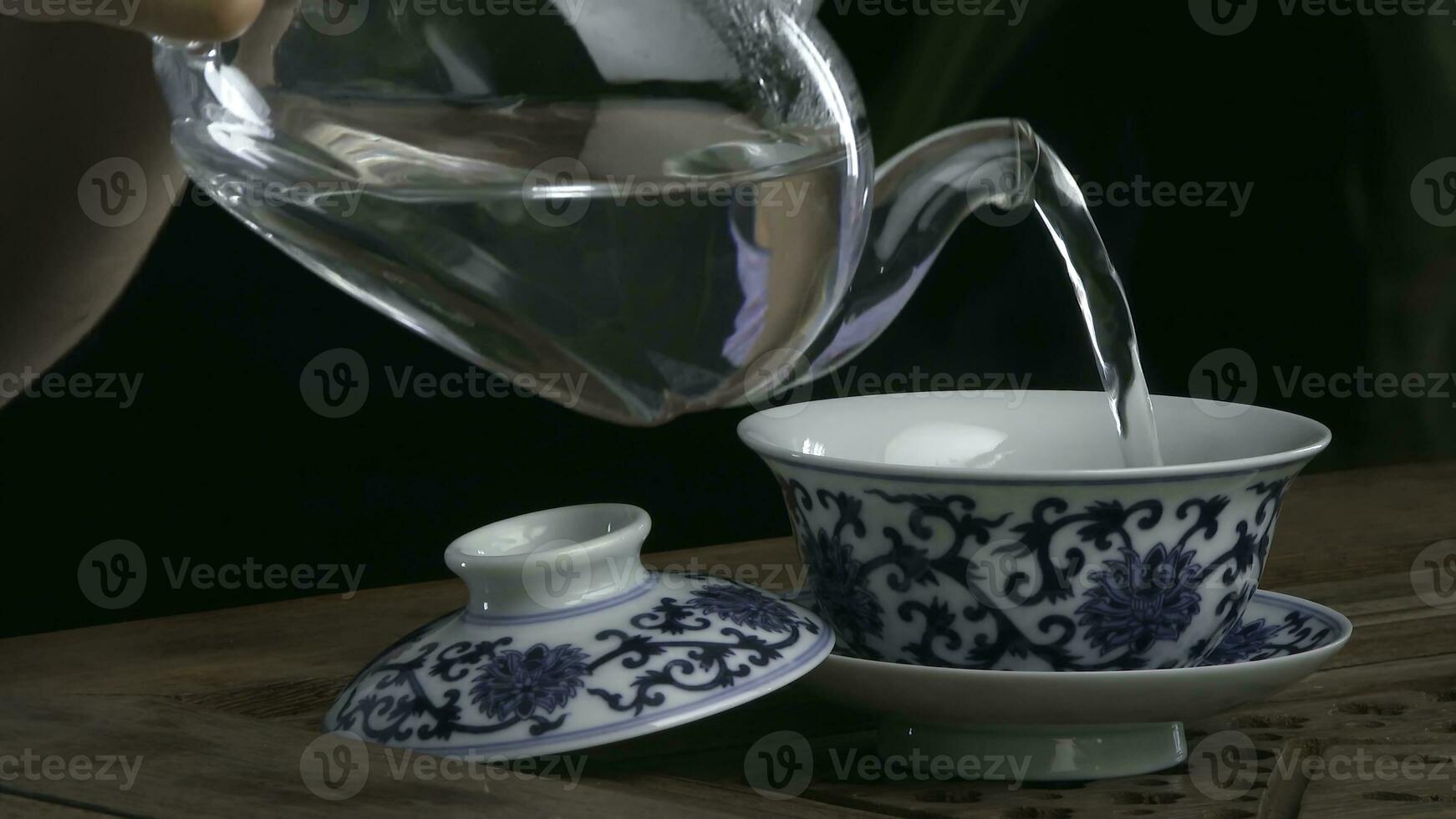 processi birra tè, tè cerimonia, coppa di appena fermentato nero tè. asiatico tè impostato su bambù stuoia, primo piano. il Cinese a partire dal un' getto teiera foto