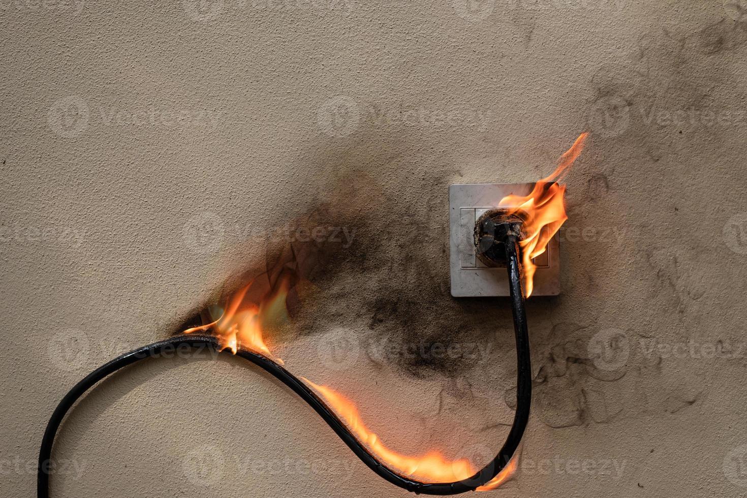 in fiamme filo elettrico presa di corrente sul muro di cemento cemento esposto sullo sfondo con spazio di copia foto