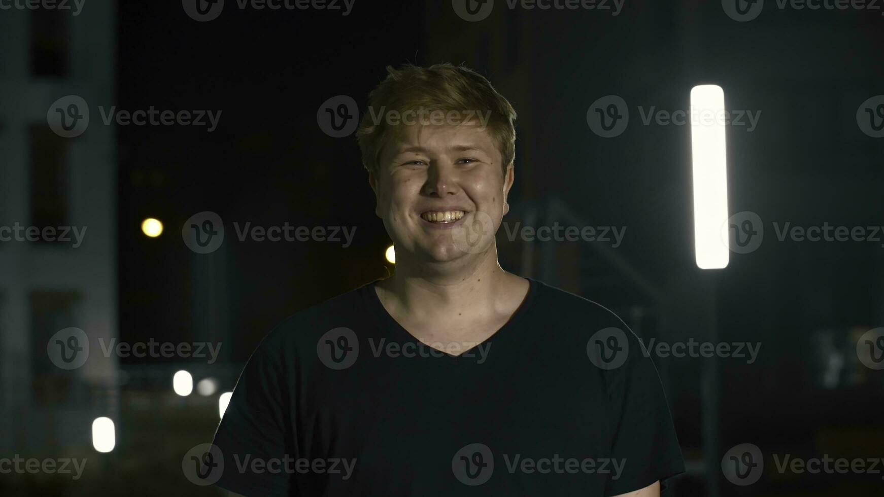 giovane uomo sorrisi e si raddrizza capelli. media. attraente paffuto uomo sorrisi e pose. attraente giovane uomo sorrisi meravigliosamente e si raddrizza capelli foto