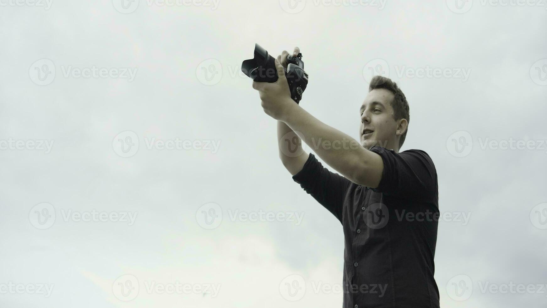 giovane uomo prende immagini su telecamera. azione. giovane uomo prende immagini con professionale telecamera. giovane uomo prende immagini di natura e architettura mentre in viaggio foto