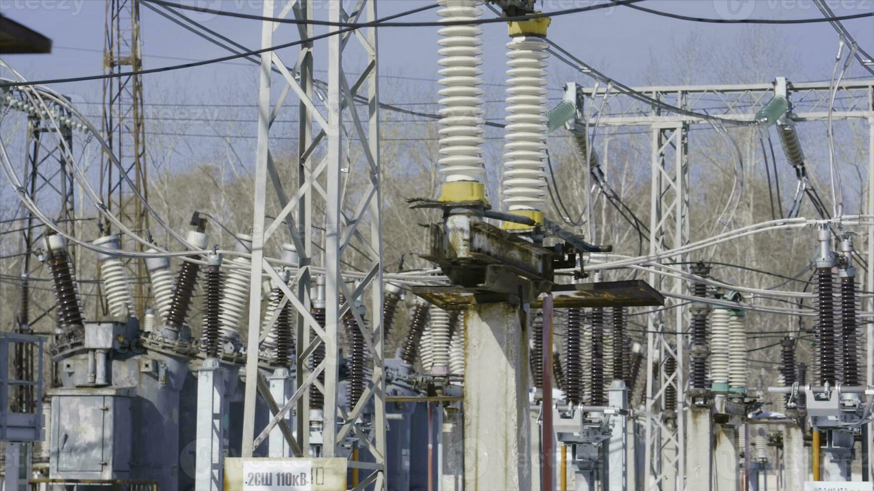 molti energia poli nel sottostazione. azione. elettrico sottostazione con potente attrezzatura e trasformatori Lavorando nel inverno. inverno chiaro giorno a elettrico energia stazione foto