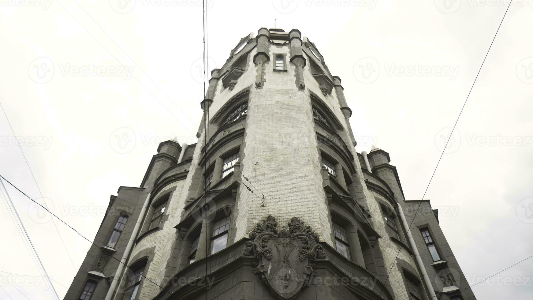 parte inferiore Visualizza su Torre di vecchio edificio su sfondo di nuvoloso cielo. azione. vecchio bianca pietra edificio è architettonico monumento di città di santo pietroburgo. storico architettonico punto di riferimento foto