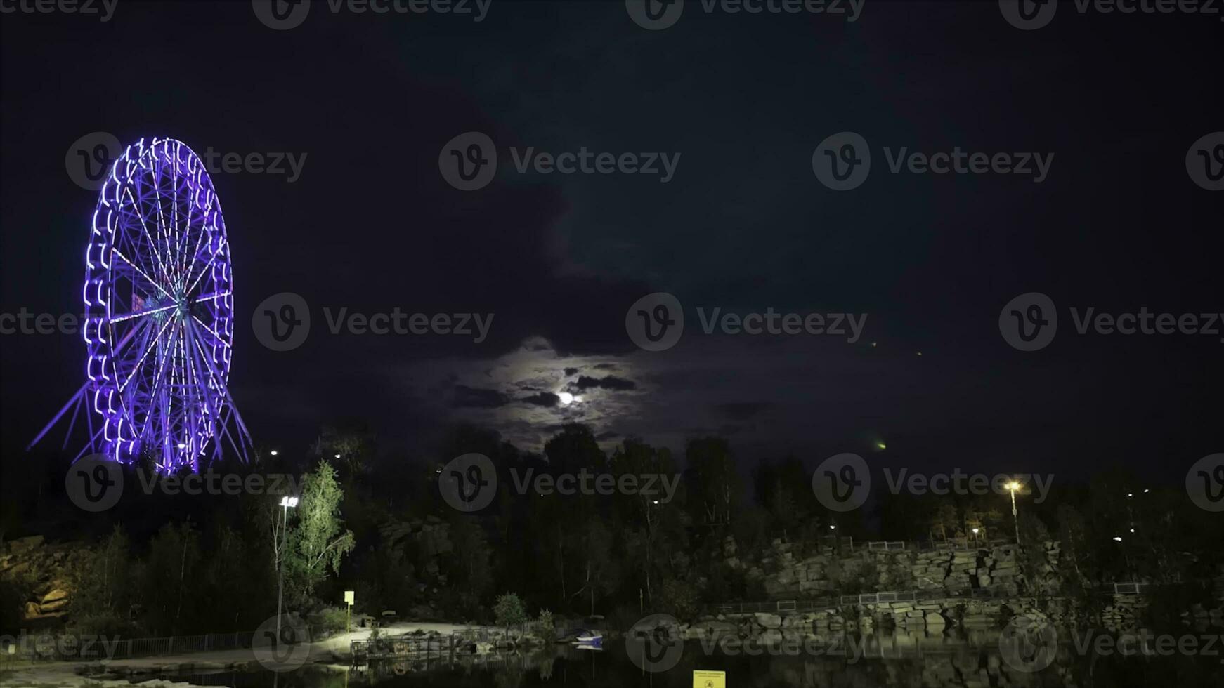 Ferris ruota nel il sera a chiaro di luna. Ferris ruota nel blu neon leggero su buio sfondo, parte di Ferris ruota con blu illuminazione contro un' nero cielo sfondo a notte. lasso di tempo. un' Visualizza di foto