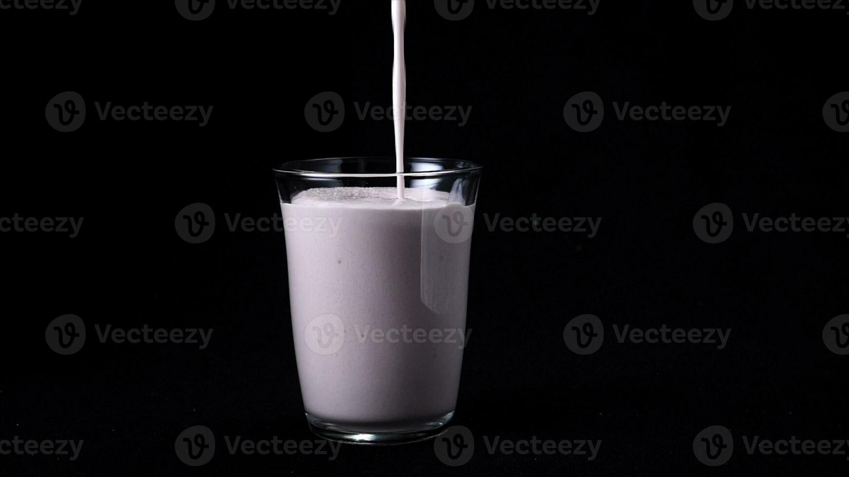 fragola latte shake isolato su nero sfondo. nel trasparente bicchiere versare viscoso rosa frappè su nero sfondo. freddo frappè foto