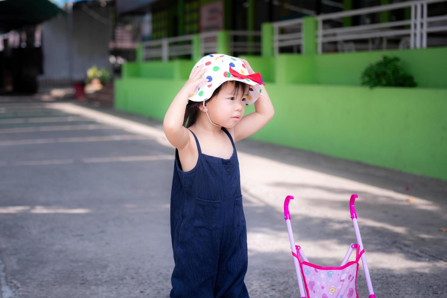 la ragazza carina indossa un cappello per proteggersi il viso dal sole mentre cammina. bambini di 2-3 anni. foto