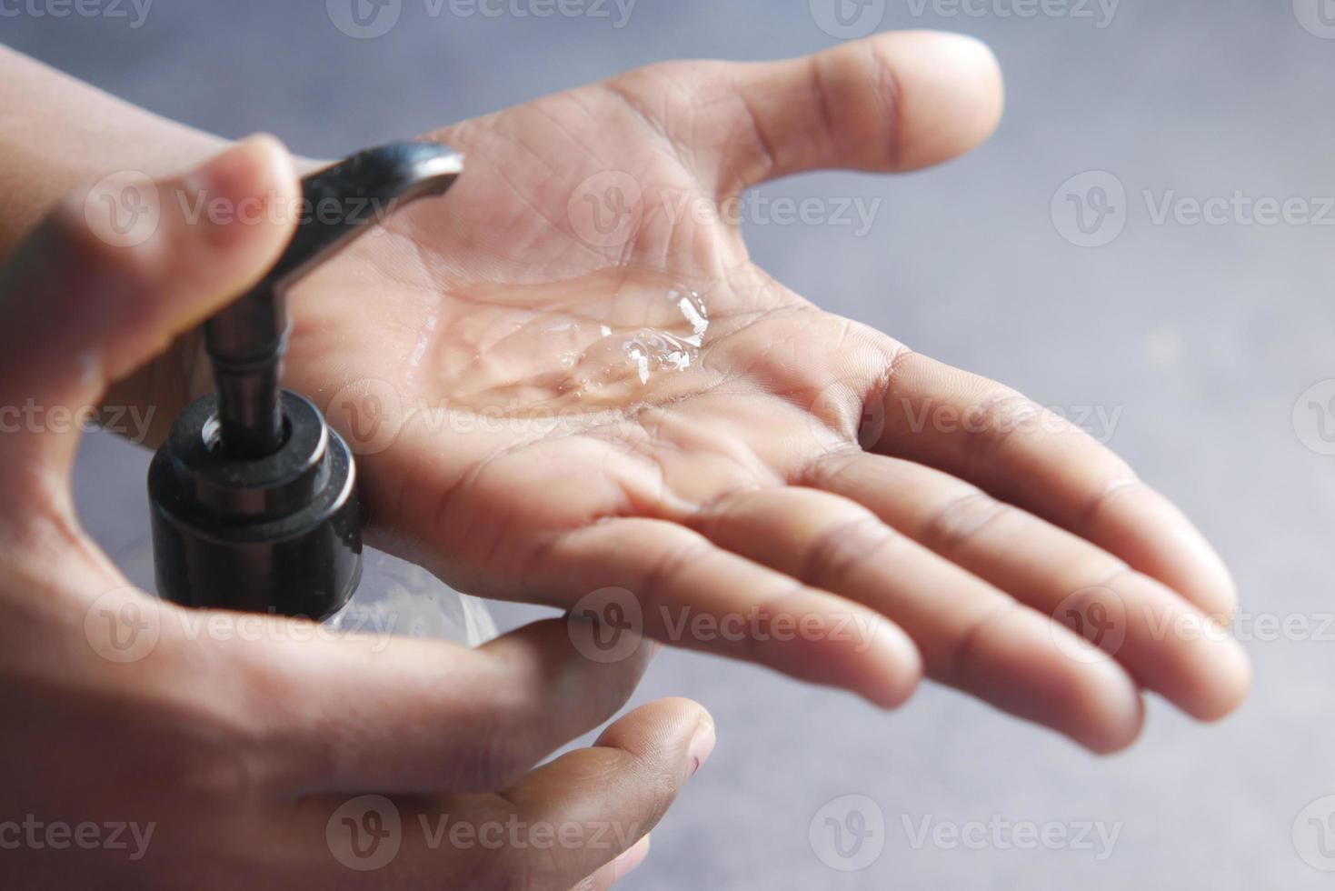 utilizzando un liquido disinfettante per prevenire il virus corona foto