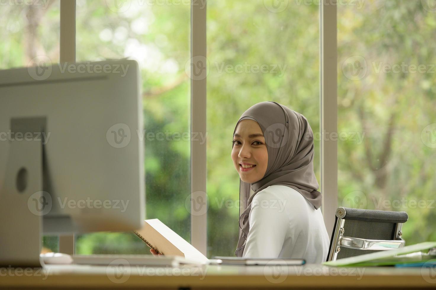 donna d'affari araba che indossa l'hijab lavora in ufficio foto